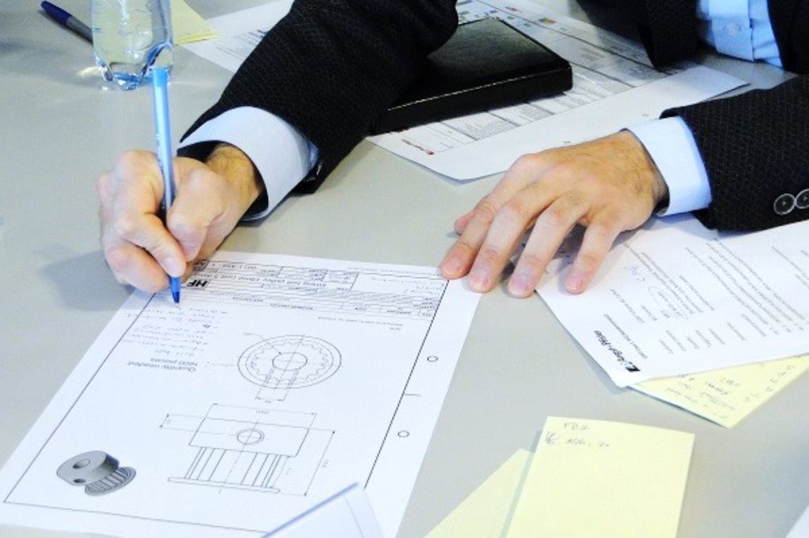 Showing engineering illustrations of a designed product on table
