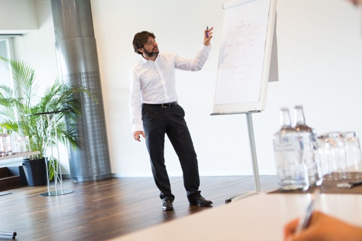 Angst+Pfister academy: speaker showing notes on a whiteboard in meeting room