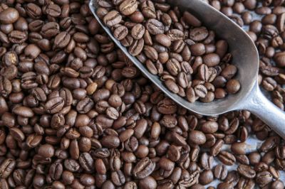 A pile of coffee beans with a ladle