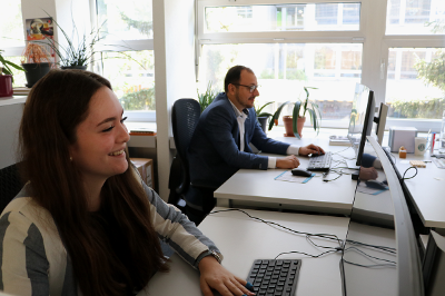 Apprentice and trainer working side by side on computer