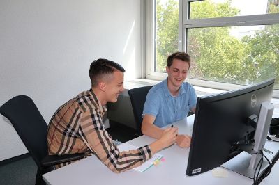 Apprentice and trainer working together in front of a computer
