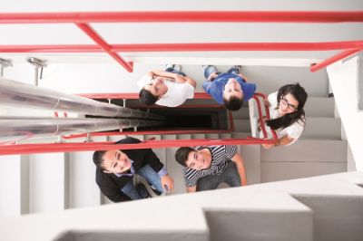 Apprentices looking up a staircase hallway